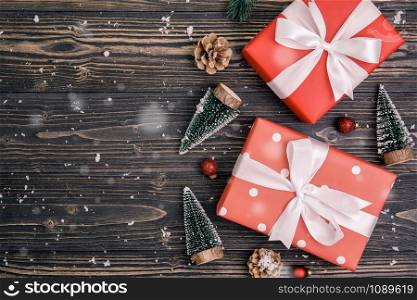 Christmas holiday composition with red gift box decoration on wooden background, new year and xmas or anniversary with presents on wood table in season, top view or flat lay.