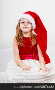 Christmas holiday concept. Toddler girl wearing Santa Claus hat and christmassy dress.. Christmas girl in santa hat festive outfit