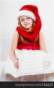 Christmas holiday concept. Toddler girl wearing Santa Claus hat and christmassy dress.. Christmas girl in santa hat festive outfit