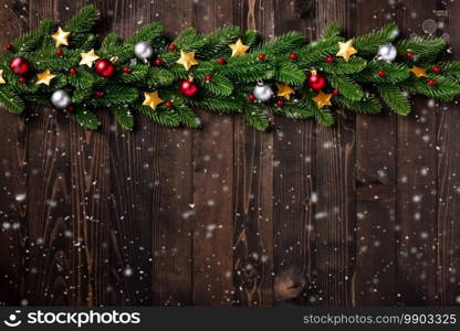 Christmas holiday garland border, Top view of tree fir branches, and Xmas stars ornament bauble decor on black wood background with copy space