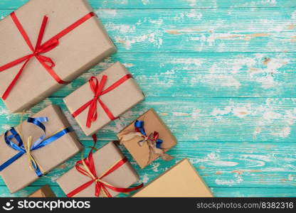 christmas holiday gift shopping background. view from above with copy space. craft paper present boxes tied from rope on blue background, top view. flat lay composition for birthday.