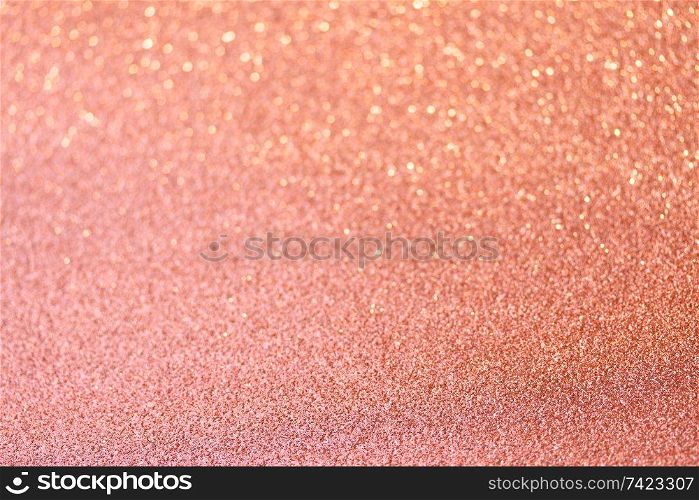 Christmas holiday glittering defocused coral pink background with bokeh lights. Christmas glittering background