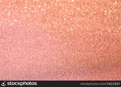 Christmas holiday glittering defocused coral pink background with bokeh lights. Christmas glittering background