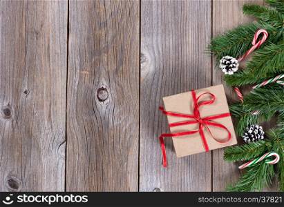 Christmas holiday wooden background with fir branches and gift box on right border
