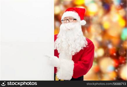 christmas, holidays, advertisement, gesture and people concept - man in costume of santa claus pointing finger to white blank billboard over red lights background