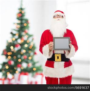 christmas, holidays, advertisement, technology and people concept - man in costume of santa claus with tablet pc computer showing blank screen over living room with tree background
