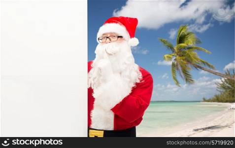 christmas, holidays, advertisement, travel and people concept - man in costume of santa claus with white blank billboard making hust gesture over tropical beach background