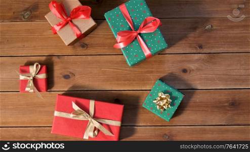 christmas, holidays and celebration concept - gift boxes on wooden boards from top. christmas gifts on wooden boards