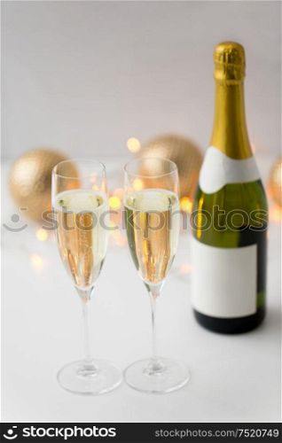christmas, holidays and celebration concept - two glasses of champagne and bottle. two glasses of champagne and bottle on christmas