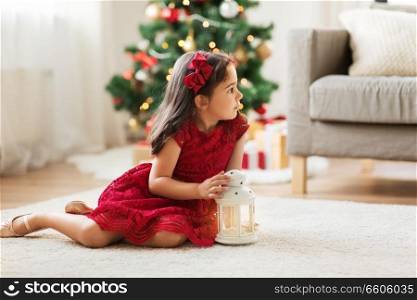 christmas, holidays and childhood concept - little girl with lantern at home. little girl with lantern at home on christmas