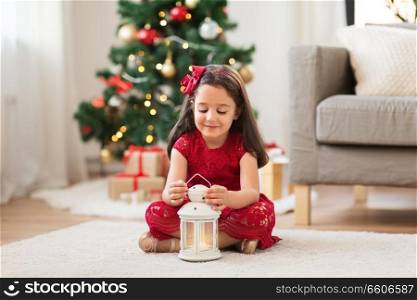 christmas, holidays and childhood concept - little girl with lantern at home. little girl with lantern at home on christmas