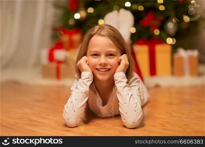 christmas, holidays and childhood concept - smiling girl at home. smiling girl at christmas home