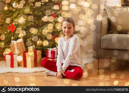 christmas, holidays and childhood concept - smiling girl at home. smiling girl at christmas home