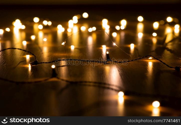 christmas, holidays and illumination concept - close up of electric garland lights in darkness. close up of electric garland lights in darkness