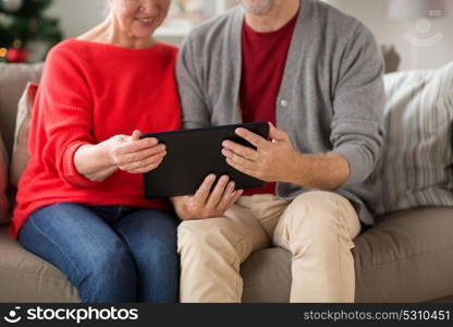 christmas, holidays and people concept - close up of happy smiling senior couple with tablet pc computer at home. senior couple with tablet pc at christmas