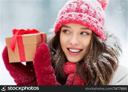 christmas, holidays and people concept - close up of happy teenage girl or young woman with gift box outdoors winter. happy young woman with christmas gift in winter