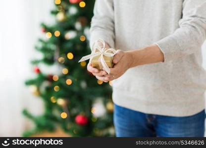 christmas, holidays and people concept - close up of man with gift box at home. close up of man with christmas gift at home