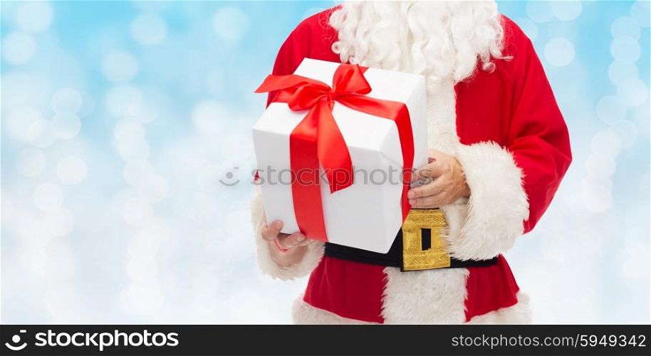 christmas, holidays and people concept - close up of santa claus with gift box over blue lights background