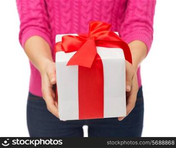 christmas, holidays and people concept - close up of woman in pink sweater holding gift box