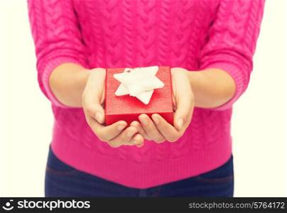christmas, holidays and people concept - close up of woman in pink sweater holding gift box