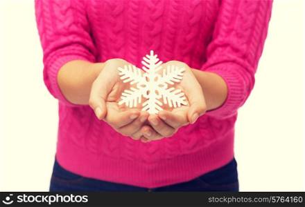 christmas, holidays and people concept - close up of woman in pink sweater holding snowflake