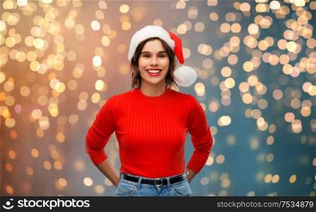 christmas, holidays and people concept - happy smiling young woman in santa helper hat over grey background. happy young woman in santa hat on christmas