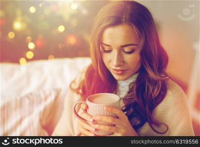 christmas, holidays and people concept - happy young woman with cup of coffee or cocoa drink at home. happy woman drinking cocoa at home for christmas