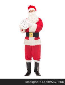 christmas, holidays and people concept - man in costume of santa claus with clock showing twelve pointing finger