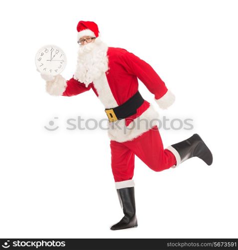 christmas, holidays and people concept - man in costume of santa claus running with clock showing twelve