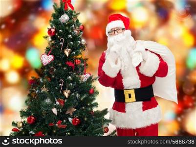 christmas, holidays and people concept - man in costume of santa claus with bag and christmas tree making hush gesture over red lights background