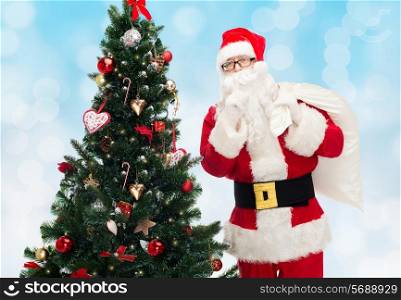 christmas, holidays and people concept - man in costume of santa claus with bag and christmas tree making hush gesture over blue lights background