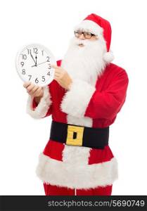 christmas, holidays and people concept - man in costume of santa claus with clock showing twelve pointing finger