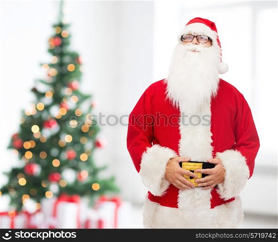 christmas, holidays and people concept - man in costume of santa claus over living room with tree background