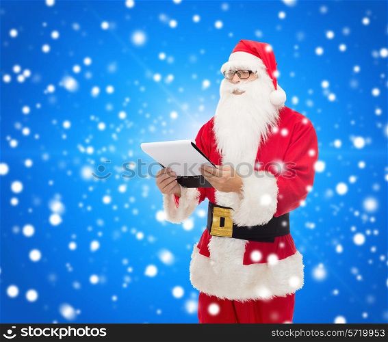 christmas, holidays and people concept - man in costume of santa claus with notepad over blue snowy background