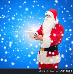 christmas, holidays and people concept - man in costume of santa claus with notepad and pen over blue snowy background