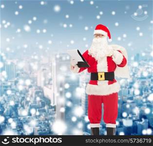 christmas, holidays and people concept - man in costume of santa claus with notepad and bag over snowy city background
