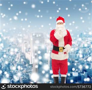 christmas, holidays and people concept - man in costume of santa claus making hush gesture over snowy city background