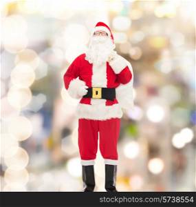 christmas, holidays and people concept - man in costume of santa claus with bag over lights background