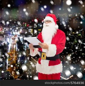 christmas, holidays and people concept - man in costume of santa claus with notepad over snowy night city background