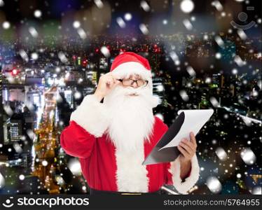 christmas, holidays and people concept - man in costume of santa claus with notepad over snowy night city background