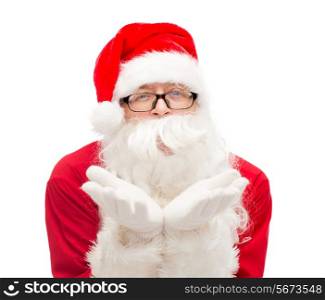 christmas, holidays and people concept - man in costume of santa claus blowing on palms