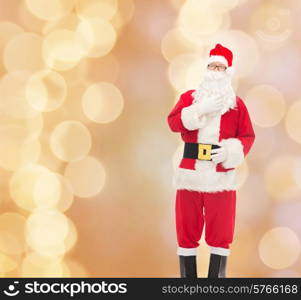 christmas, holidays and people concept - man in costume of santa claus over beige lights background