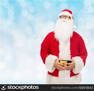 christmas, holidays and people concept - man in costume of santa claus over blue lights background