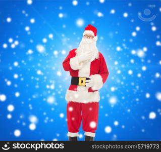 christmas, holidays and people concept - man in costume of santa claus over blue snowy background