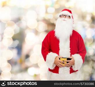 christmas, holidays and people concept - man in costume of santa claus over lights background