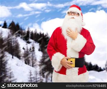 christmas, holidays and people concept - man in costume of santa claus over snowy mountains background