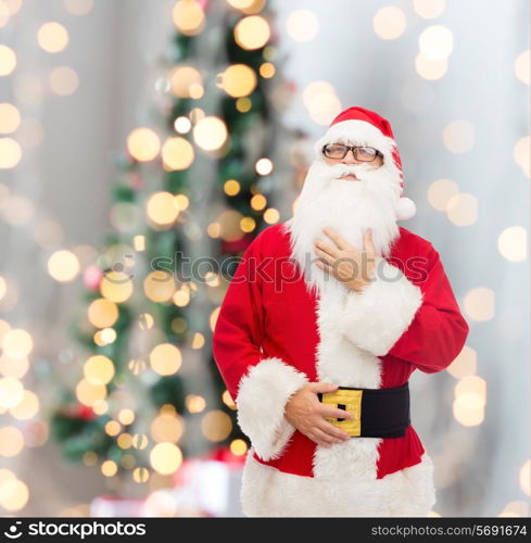 christmas, holidays and people concept - man in costume of santa claus over tree lights background