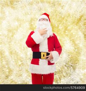 christmas, holidays and people concept - man in costume of santa claus over yellow lights background