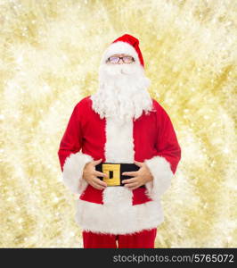 christmas, holidays and people concept - man in costume of santa claus over yellow lights background