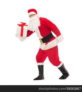 christmas, holidays and people concept - man in costume of santa claus running with gift box